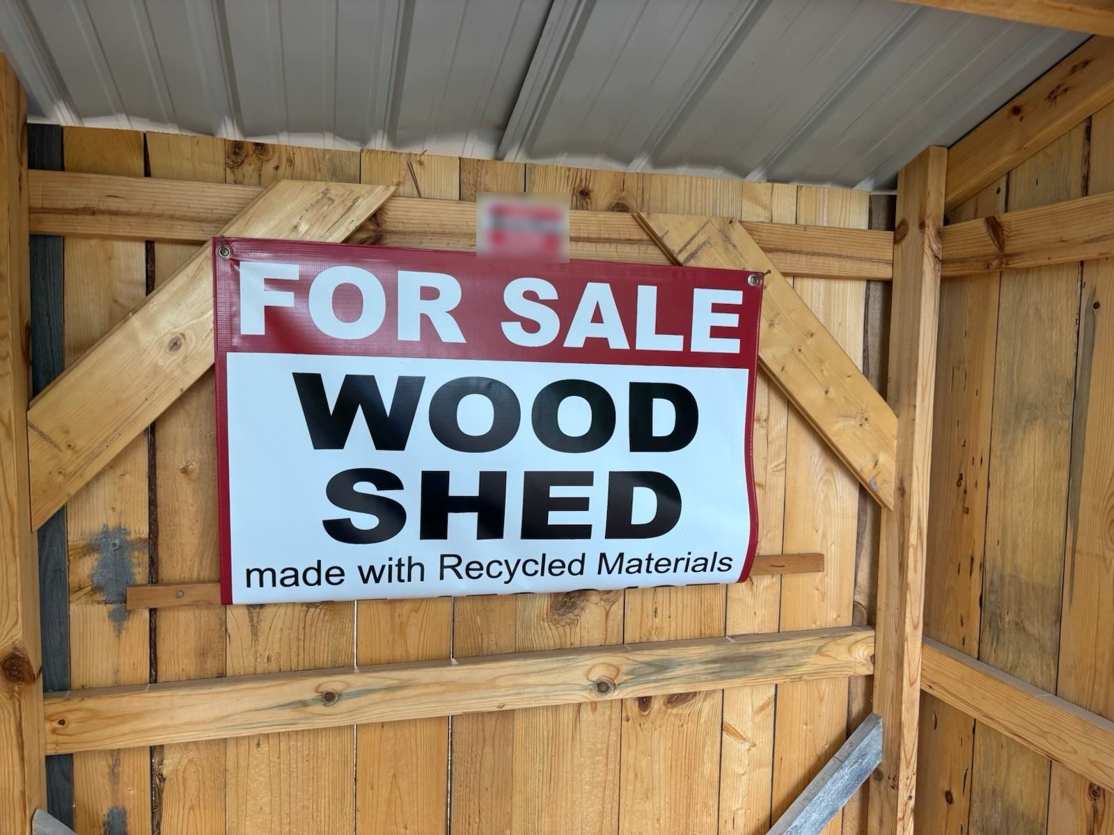 For sale sign inside a shed reading: Wood Shed, made with Recycled Materials
